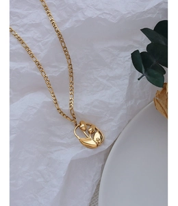 Detalle de un colgante de tulipán en oro de 18k con elegante cadena tipo Fígaro