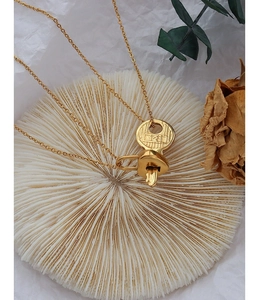 Detailed macro view of gold-plated key and heart lock pendant necklace with 121 engraving