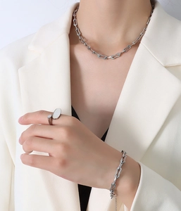 Détail de l'ensemble de bijoux en argent avec collier et bracelet sur blazer