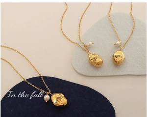 Detail of three 18K gold plated necklaces with irregular molten metal pendants and pearls
