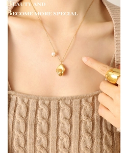 Detail view of 18K gold plated geometric pebble pendant necklace and thick band ring set