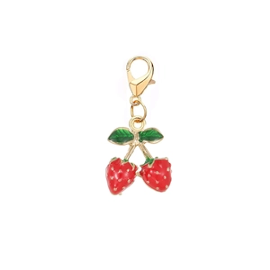 Dettaglio del ciondolo a fragola con smalto rosso, foglie verdi e chiusura a moschettone d'oro