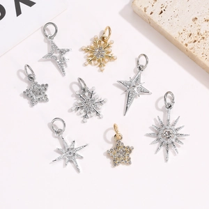 Detailed view of silver and gold star charms with micro-pave crystals and pearls