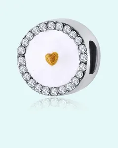Detail of silver round charm with pavé zircon border and a golden heart center