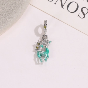 Macro view of silver reindeer pendant with green enamel and tiny zircon stones