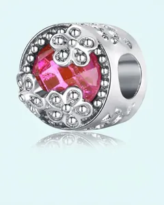 Macro shot of silver flower charm with pink crystal bead for DIY bracelet jewelry