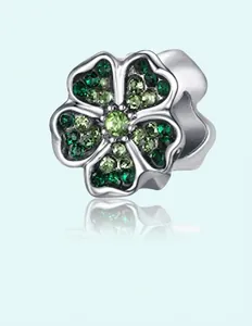 Detailed macro view of a silver flower charm with gradient green cubic zirconia stones