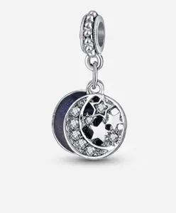 Detailed view of silver charm with hollow star moon design and blue enamel night sky background