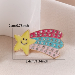 Detailed close-up of a smiling yellow star brooch with sparkling rainbow rhinestone tail