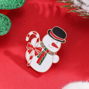 Christmas snowman enamel brooch with top hat and candy cane on festive red background