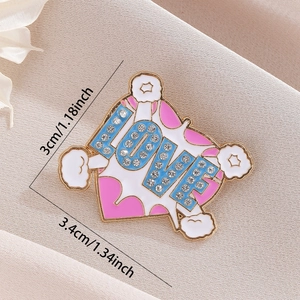 Detailed macro view of LOVE brooch with rhinestones and size dimensions in 3cm x 3.4cm