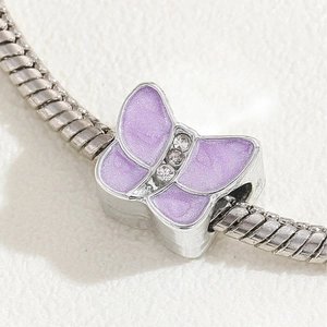 Silver butterfly charm with purple enamel and zircon inlay on snake chain bracelet