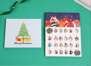 Detailed view of a 24-day Christmas advent calendar jewelry set with festive charms