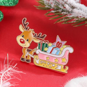 Close-up of a cartoon reindeer pulling a pink sleigh enamel brooch on festive red cloth