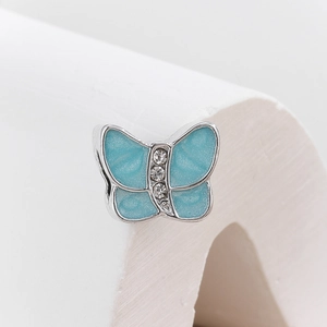 Macro shot of butterfly charm with blue enamel glitter and inlaid cubic zirconia crystals