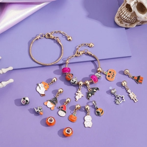 Set bracciale Halloween con ciondoli a zucca e teschio su sfondo di raso viola elegante