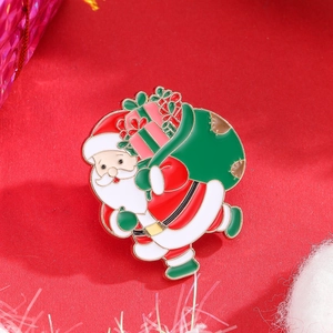 Detail view of colorful Santa Claus enamel brooch with green gift bag and gold metal edges