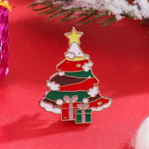 Detailed view of an enamel Christmas tree brooch with festive decorations and gold trim