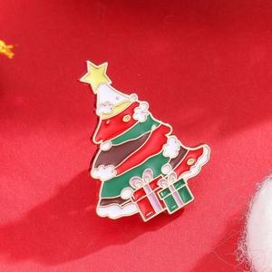 Detailed view of a Christmas tree enamel brooch with golden trim and gift boxes