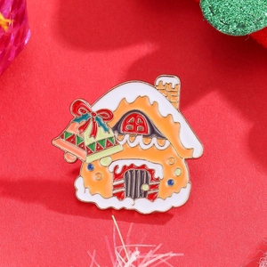 Colorful gingerbread house Christmas brooch with festive bells on red textured background