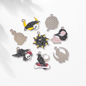 Macro shot of Gothic Halloween charms including skulls, ravens, and crescent moons