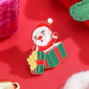 Enamel Santa Claus gift box brooch with festive Christmas decorations on red background