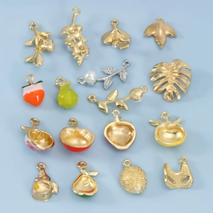 Detail of colorful fruit and leaf alloy pendants with vibrant enamel drips and pearls