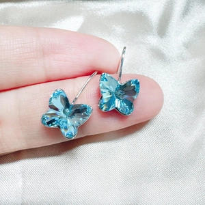 Elegante Schmetterlingsohrringe mit funkelnden hellblauen Kristallen in Silberoptik