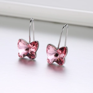 Makroaufnahme der rosa Kristall-Schmetterlings-Ohrhänger mit silbernen Haken und Schliff