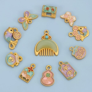 Macro detail of Chinese enamel pendants featuring koi fish, butterfly, and lucky charms