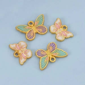 Detailed macro view of four butterfly charms with gold-plated edges and enamel wings