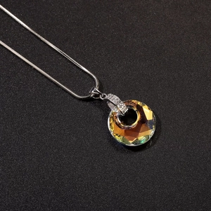 Vista de cerca del colgante de cristal ámbar facetado con diamantes en cadena de serpiente plata