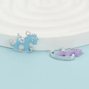Macro view of blue and purple enamel rocking horse charms with subtle rhinestone eyes