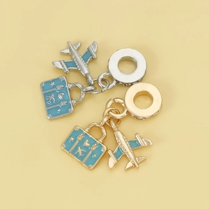 Travel themed charm set with airplane and suitcase pendants in gold and silver finish