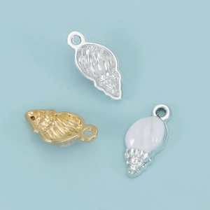 Gedetailleerde weergave van drie schelphangers in goud, zilver en emaille voor DIY-sieraden