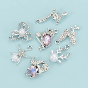 Detalle de colgantes DIY con gemas violetas, diamantes de imitación y perlas