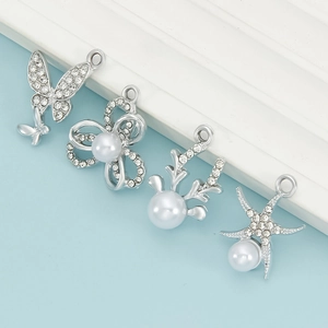 Conjunto detallado de dijes de aleación plateada con diamantes y perlas en fondo azul