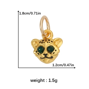 Detail of a golden leopard charm with green gemstone eyes and black spot patterns