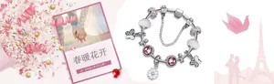 Nahaufnahme von glitzernden Schneeflocken-Anhängern und rosa Glasperlen auf DIY-Armband