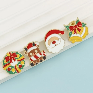 Set of four Christmas enamel pins including wreath, reindeer, Santa, and bells