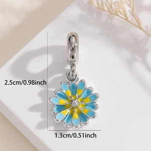 Close-up of daisy charm with blue and yellow enamel petals and crystal center