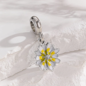 Macro shot of a silver daisy pendant with white and yellow enamel and a small center diamond