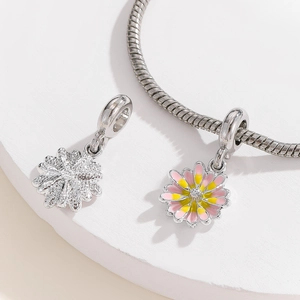 Macro detail of daisy flower charms with pink enamel and textured silver petals