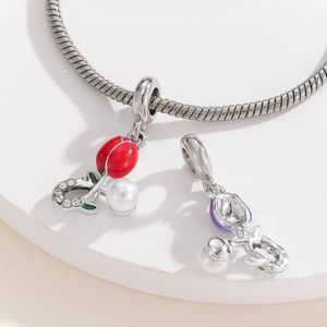 Detail of silver snake chain bracelet with red tulip charm and artificial pearl