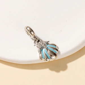 Macro view of blue enamel shell pendant with small starfish and sparkling crystals
