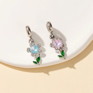 Detailed close-up of floral charms with vibrant blue and purple stones and green leaves