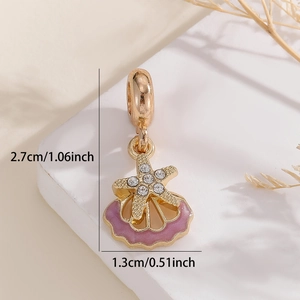 Macro shot of gold starfish and pink enamel shell charm with measurement of 2.7cm