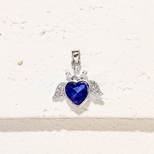 Colgante de corazón con alas y gema azul facetada en un soporte de plata brillante