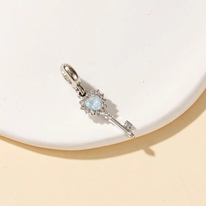 Exquisite silver heart-shaped blue opal key pendant with sparkling zircon accents on white base