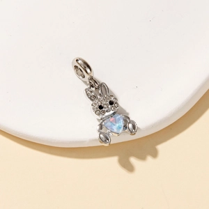 Macro shot of a silver rabbit charm with heart-shaped opal and crystal pavé details
